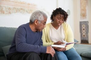 A senior man and caregiver engage in a meaningful conversation at home.